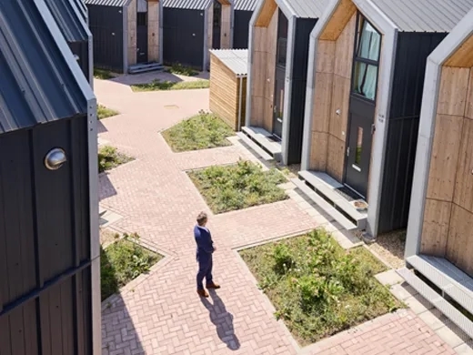 Heijmans One met man naast de woningen