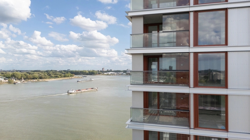Close up van balkons en raampartijen met uitzicht over de Maas