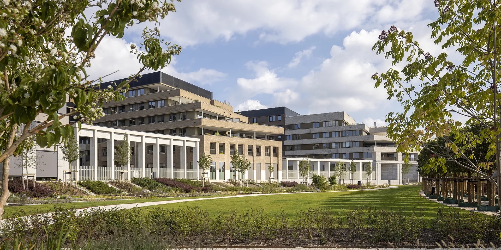 Zijaanzicht van het Greenville gebouw met bomen en gras