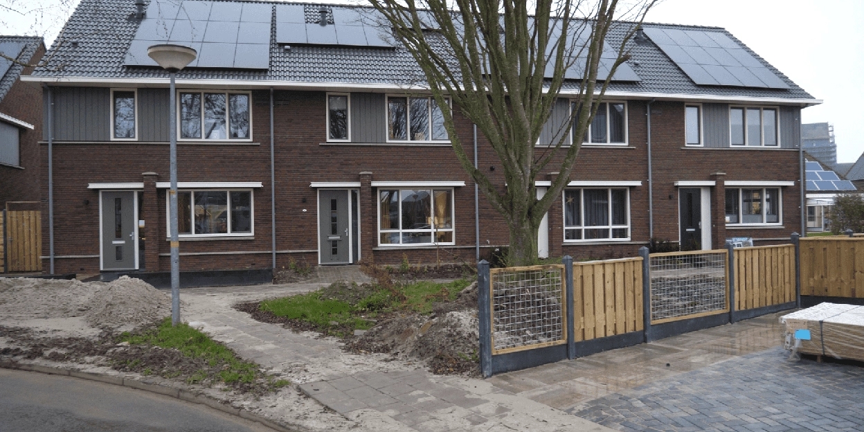 Vooraanzicht van de rijwoningen met een boom