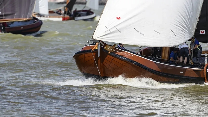 Friese skûtsje zeilboot met een witte fok varend op een meer