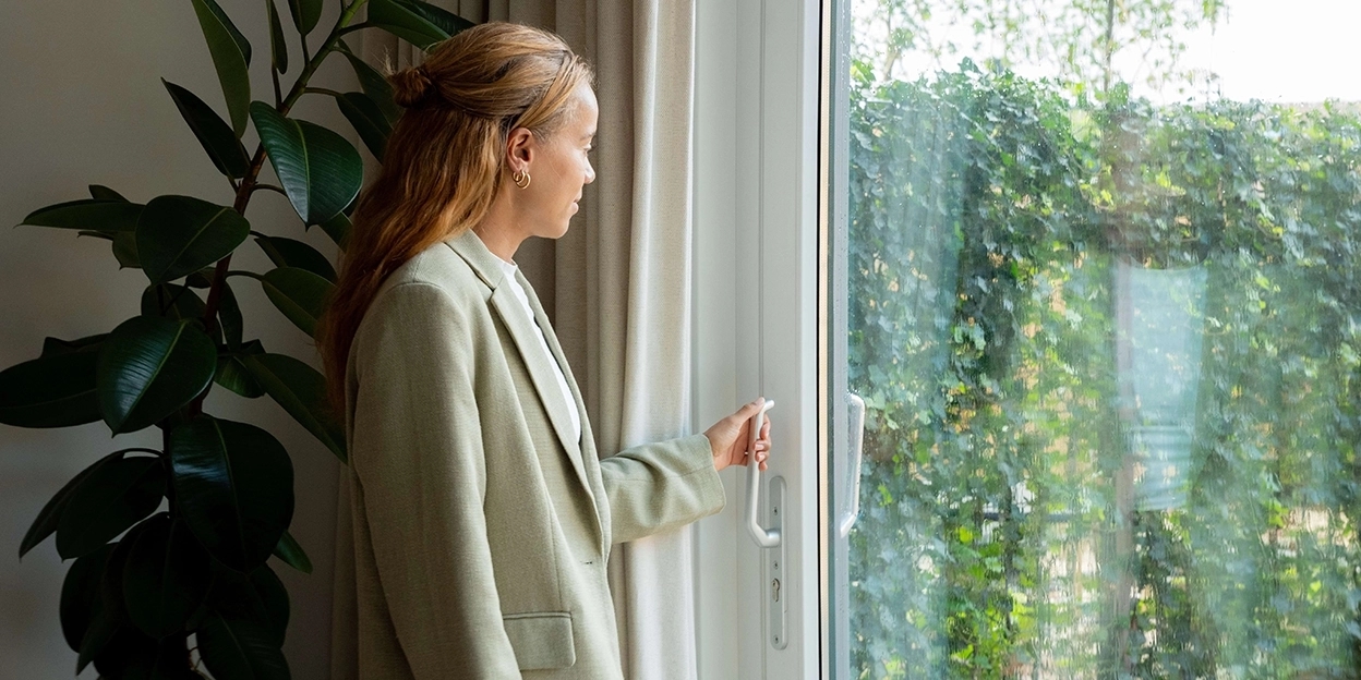 Jonge vrouw doet de deur naar haar achtertuin open