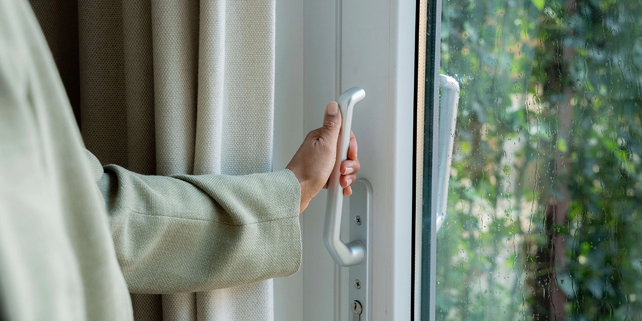 Vrouw houdt de deurklink van haar achterdeur vast