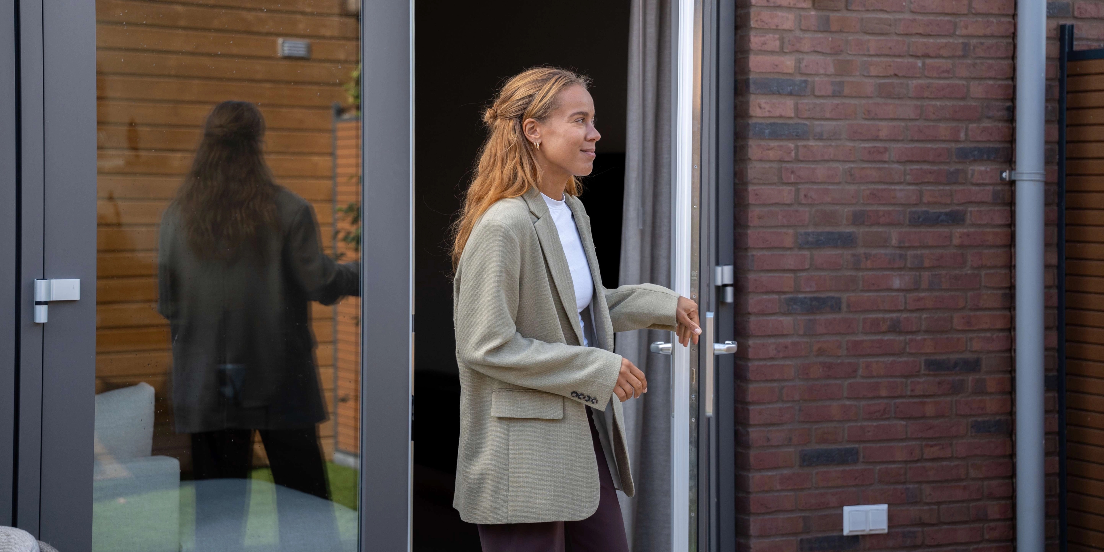 Vrouw stapt haar tuin in vanuit de woonkamer