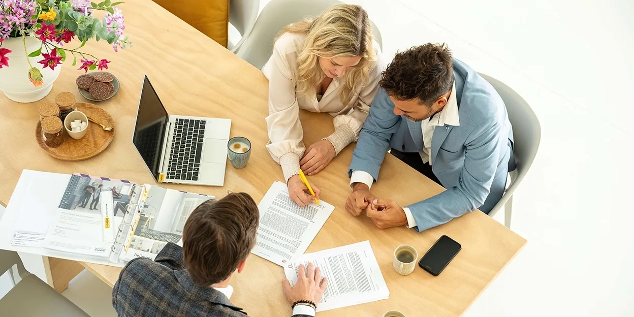 Man en vrouw ondertekenen het contract van hun nieuwbouwwoning