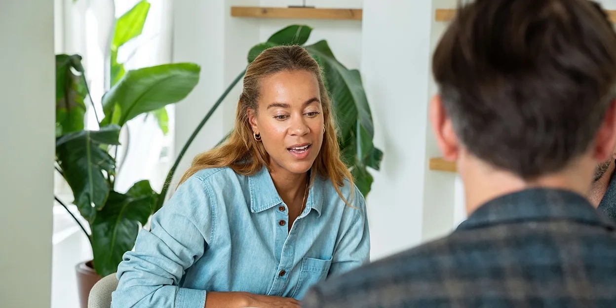 Jonge vrouw in gesprek met haar kopersbegeleider