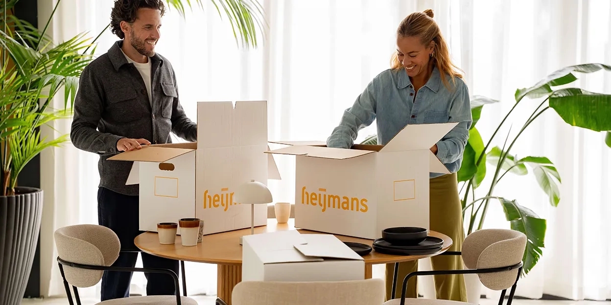 Man en vrouw pakken op tafel hun verhuisdozen in